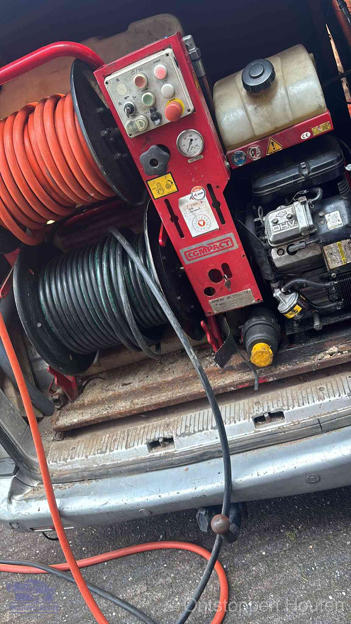 Een rood hogedruk-rioolreinigingstoestel met slangen in de laadbak van de bedrijfsbus, apparatuur voor een hardnekkige wc-verstopping in Houten