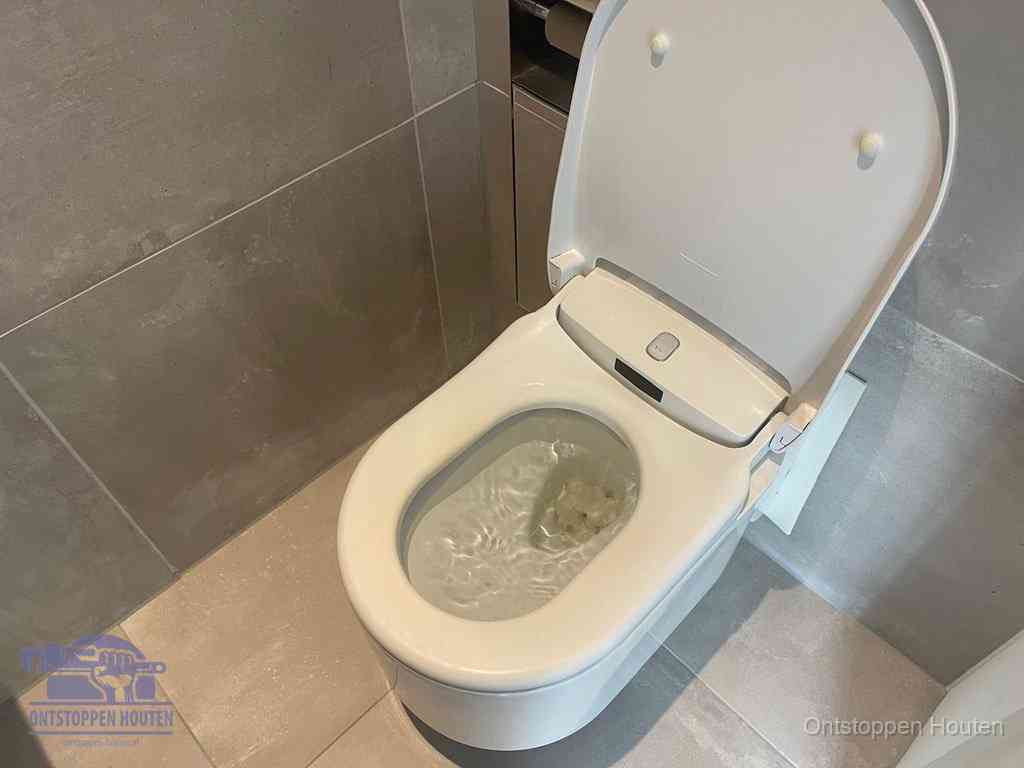 Een toiletpot vol troebel water met drijvend papier en restanten, de meest voorkomende oorzaak van een verstopte wc in Houten