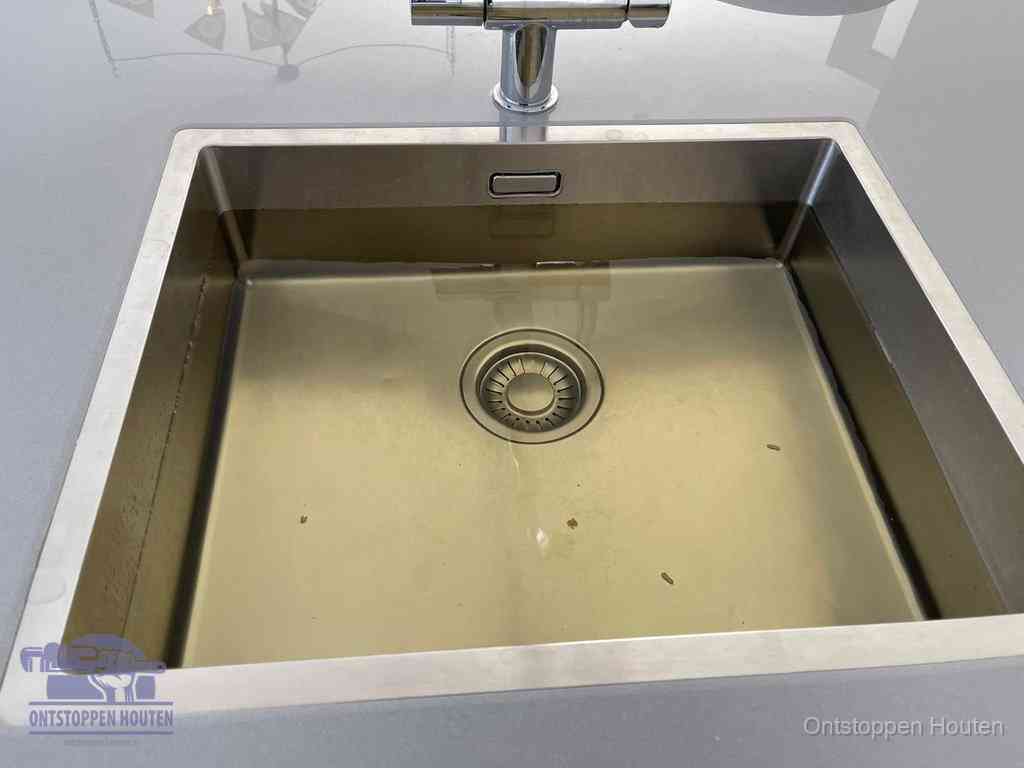 Stilstaand water in een rvs spoelbak dat niet wegloopt, een duidelijk signaal van een gootsteenverstopping in Houten